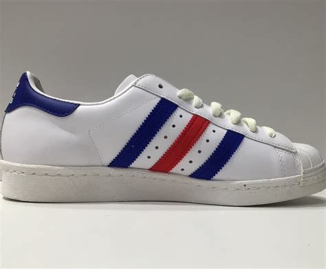 white adidas with blue stripes